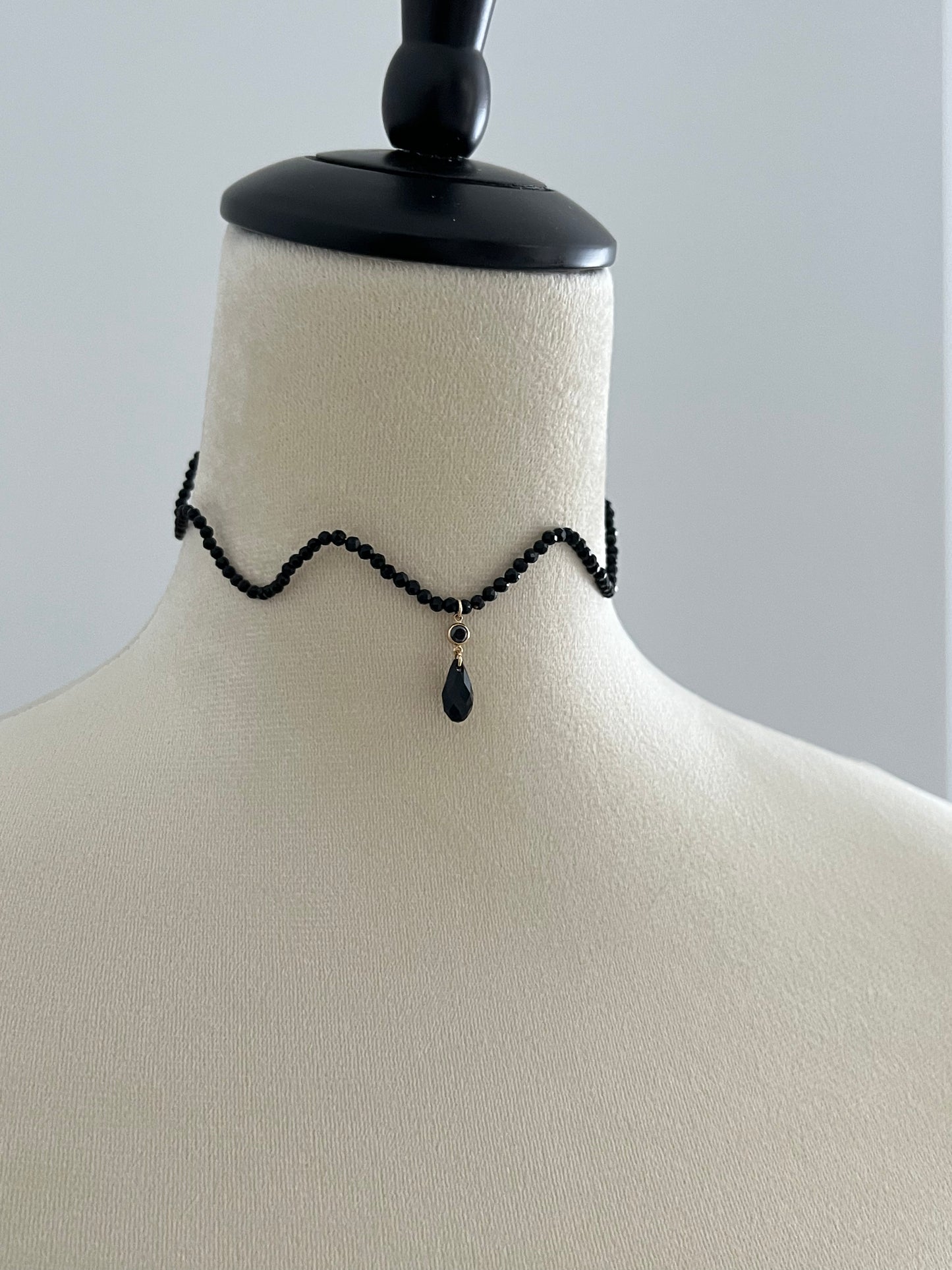 Black wave curve crystal choker necklace on a mannequin