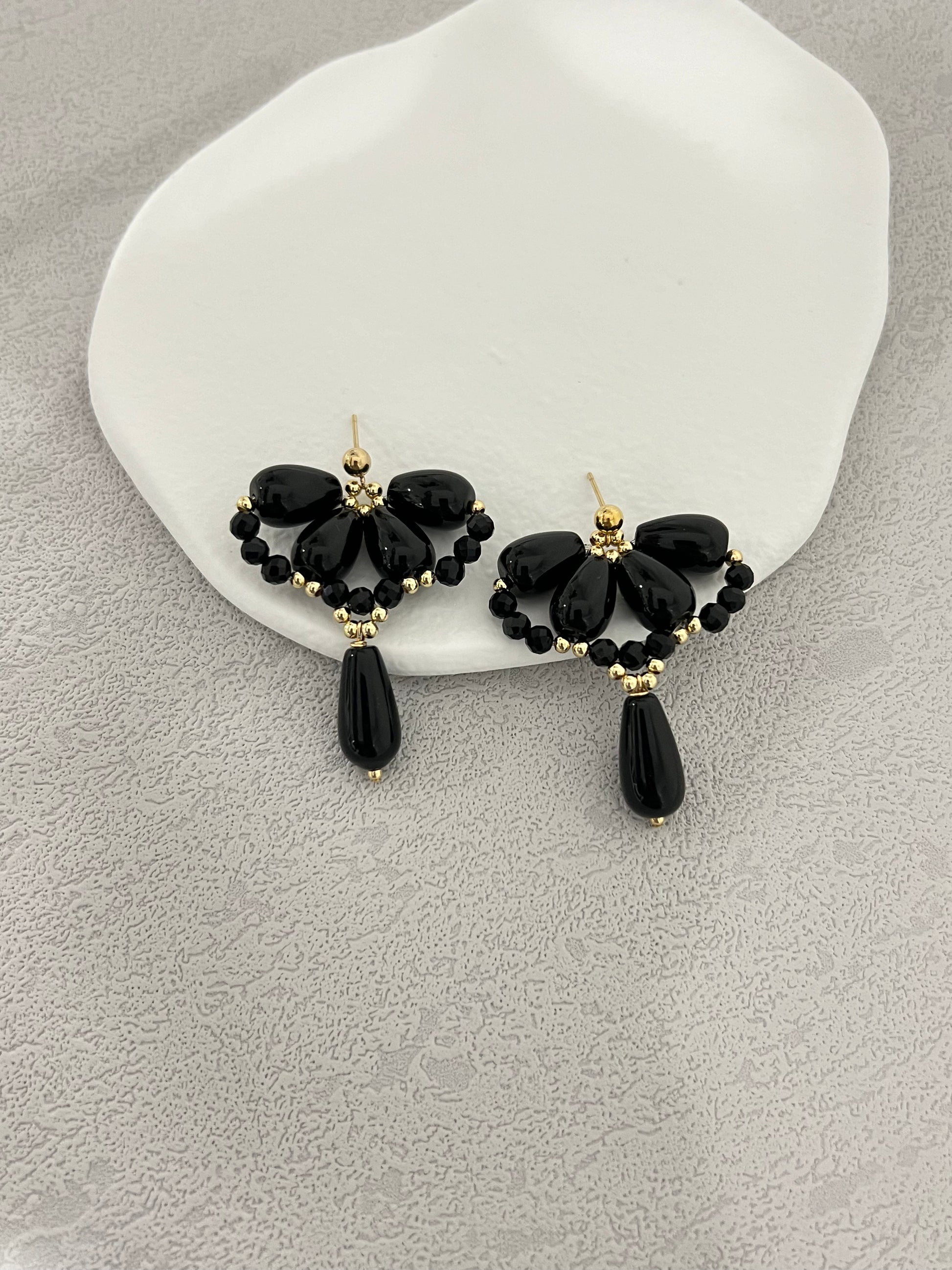 Black agate waterdrop earrings on a white plate