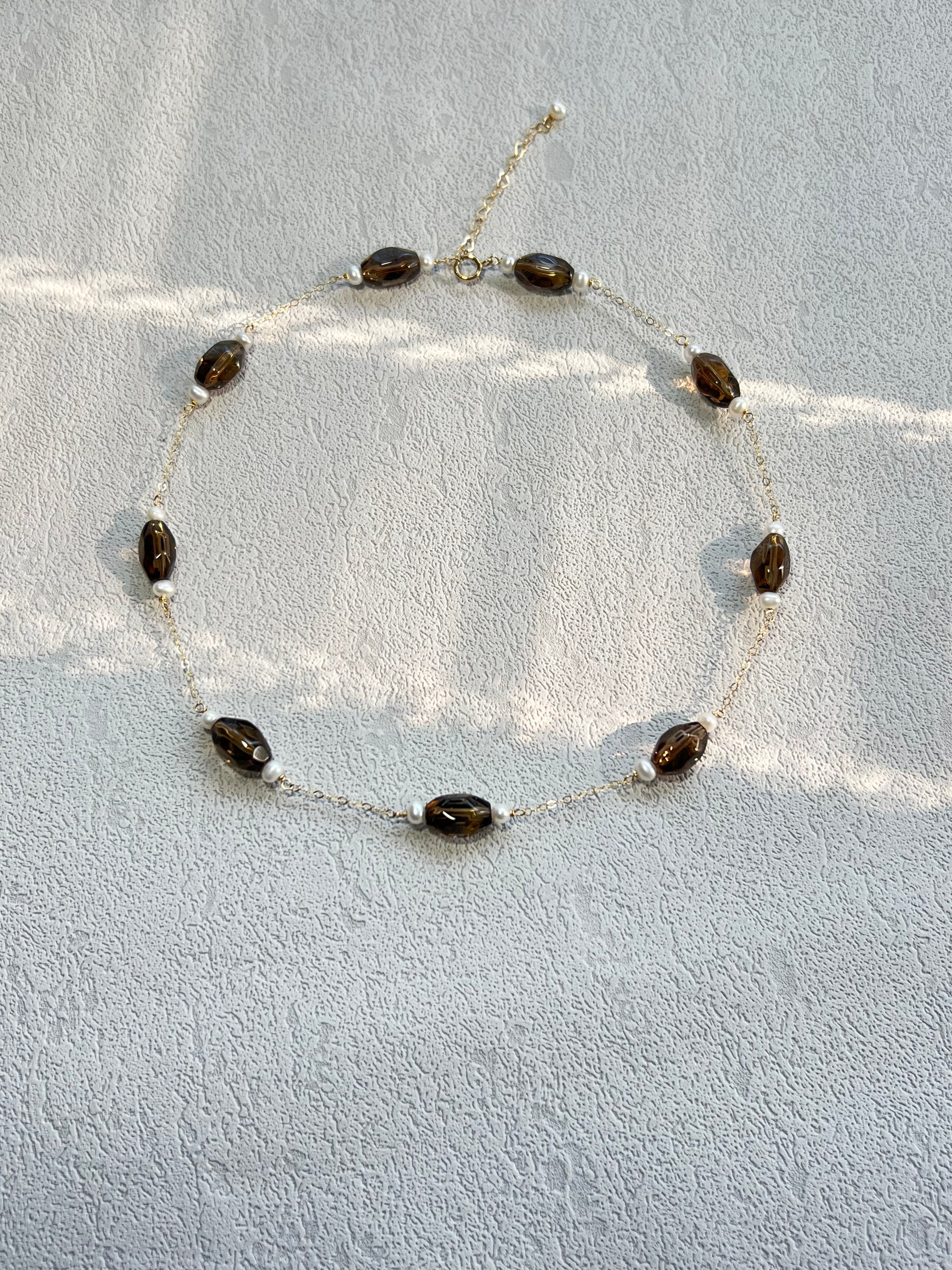 Smoky quartz & pearl choker necklace under light