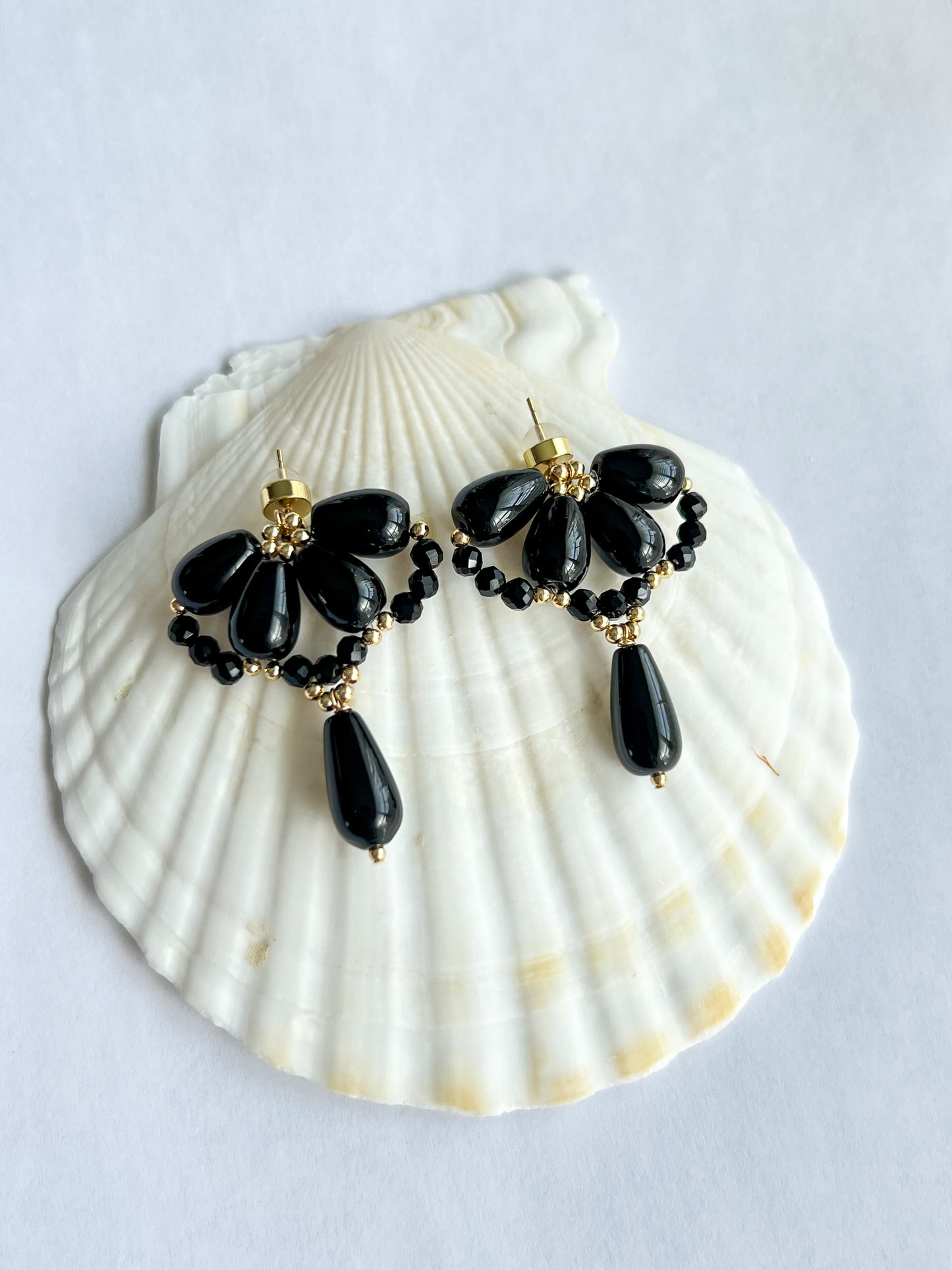 Black agate waterdrop earrings on a big shell