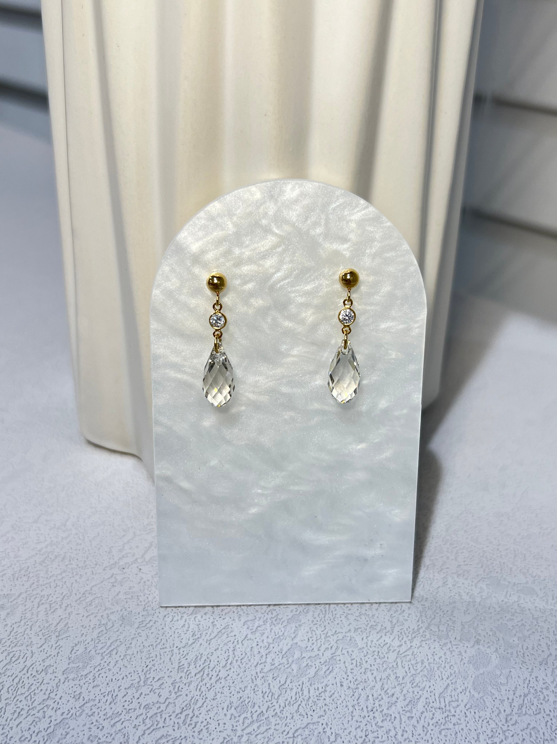 Shor Swarovski crystal earrings next to a vase