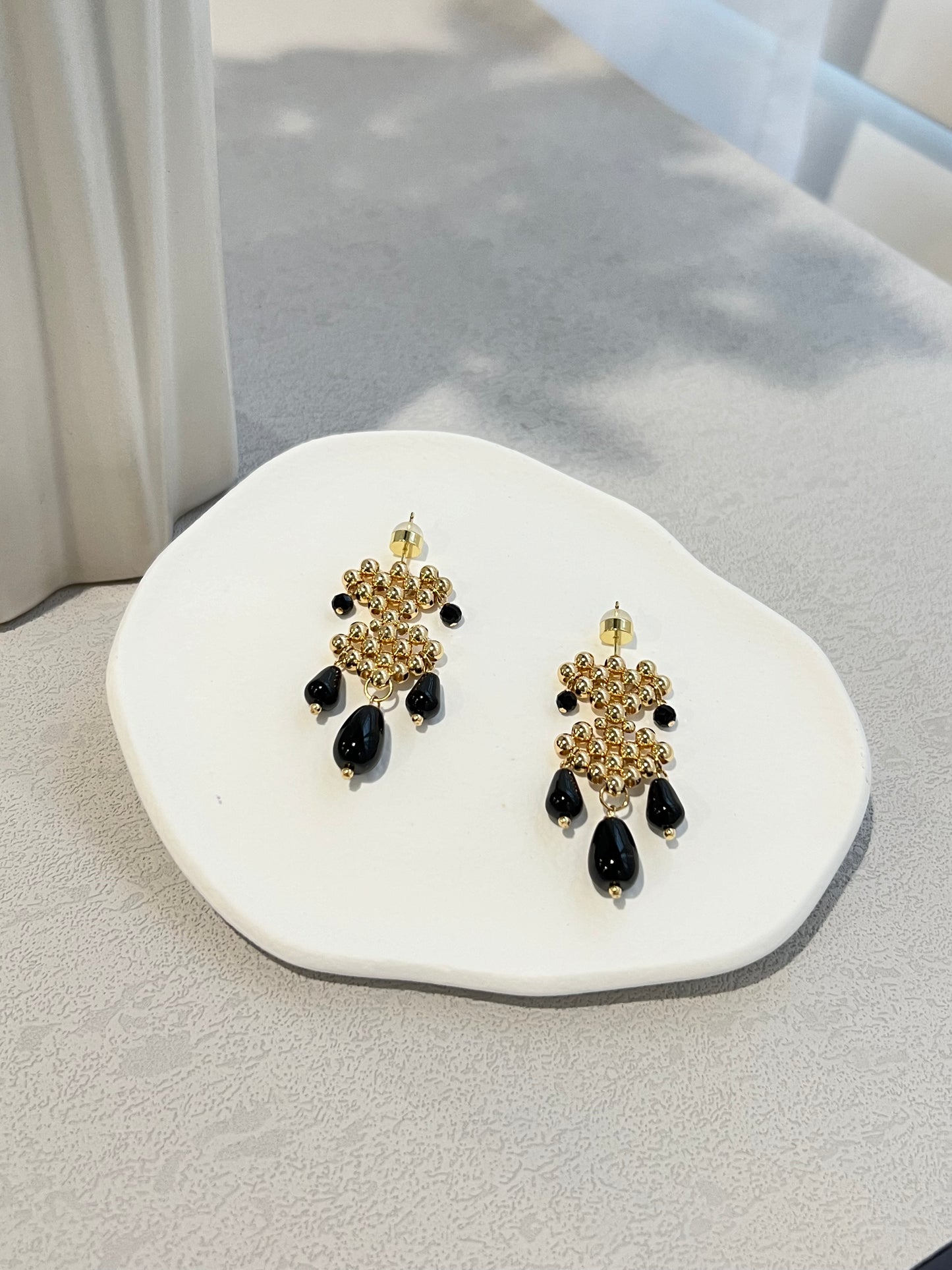 Double hearts earrings with black agate on a white plate