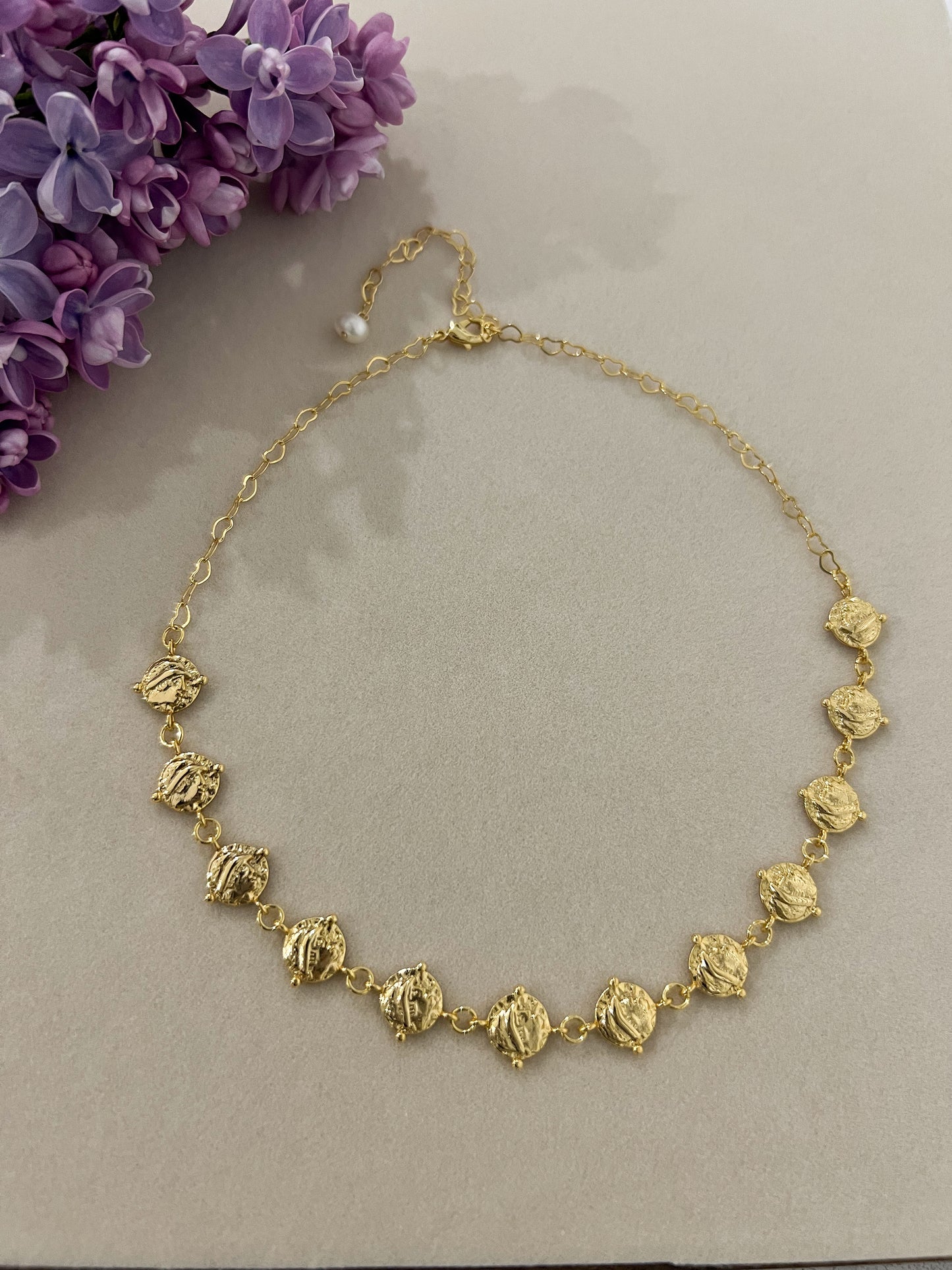 24k gold plated cascading coin choker necklace next to flowers