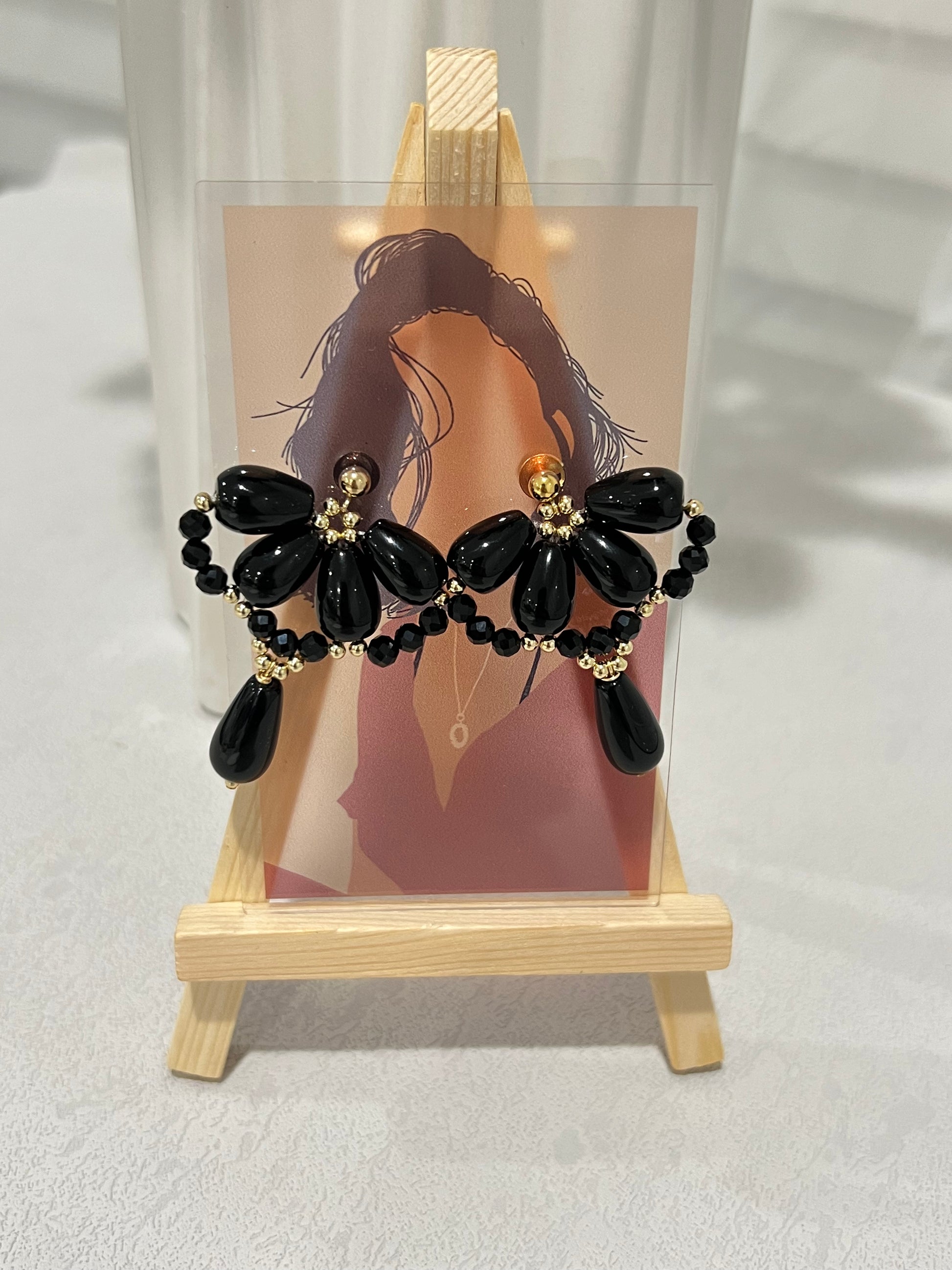 Black agate waterdrop earrings hung on a portrait card