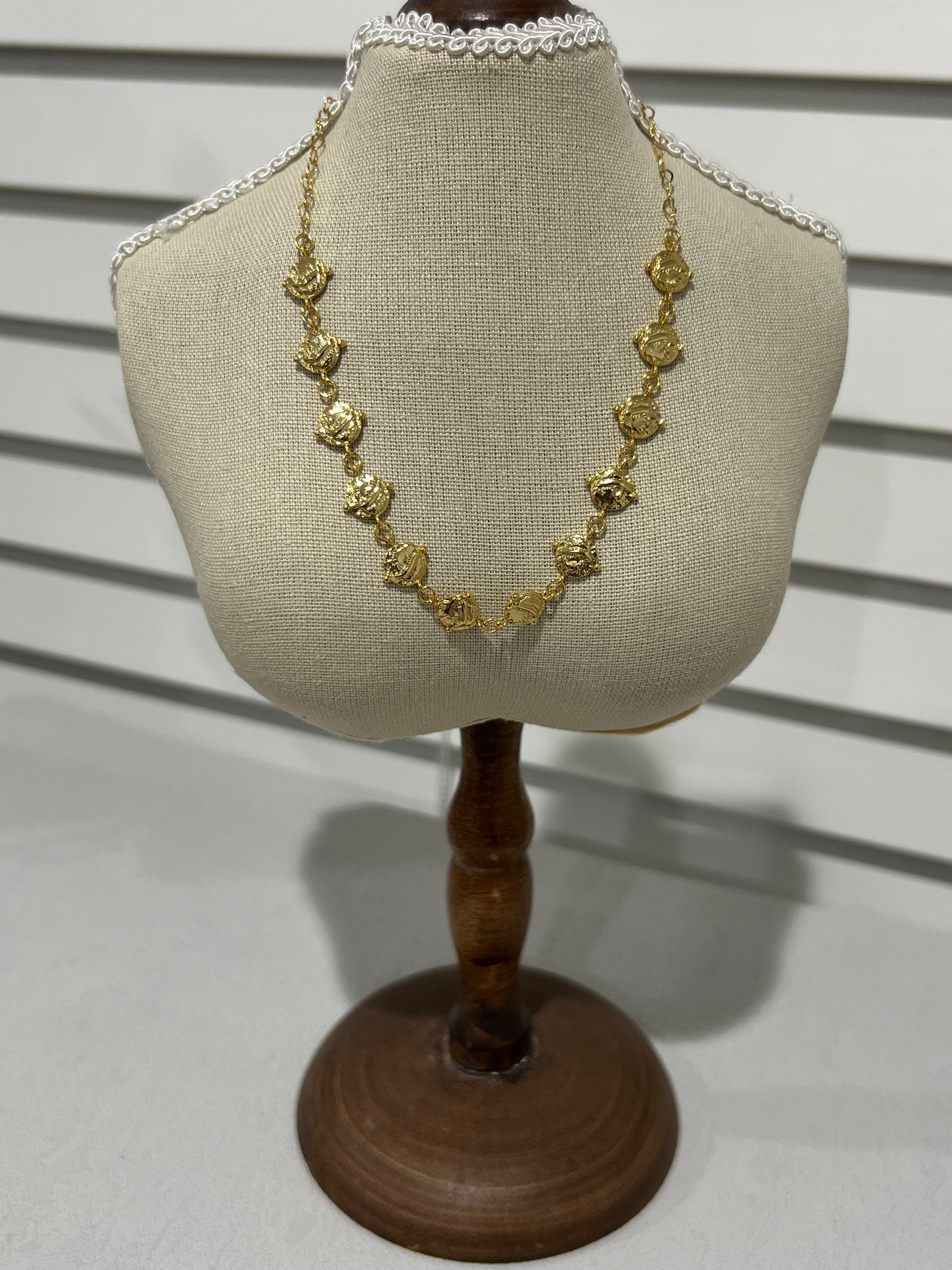 24k gold plated cascading coin necklace on a small mannequin