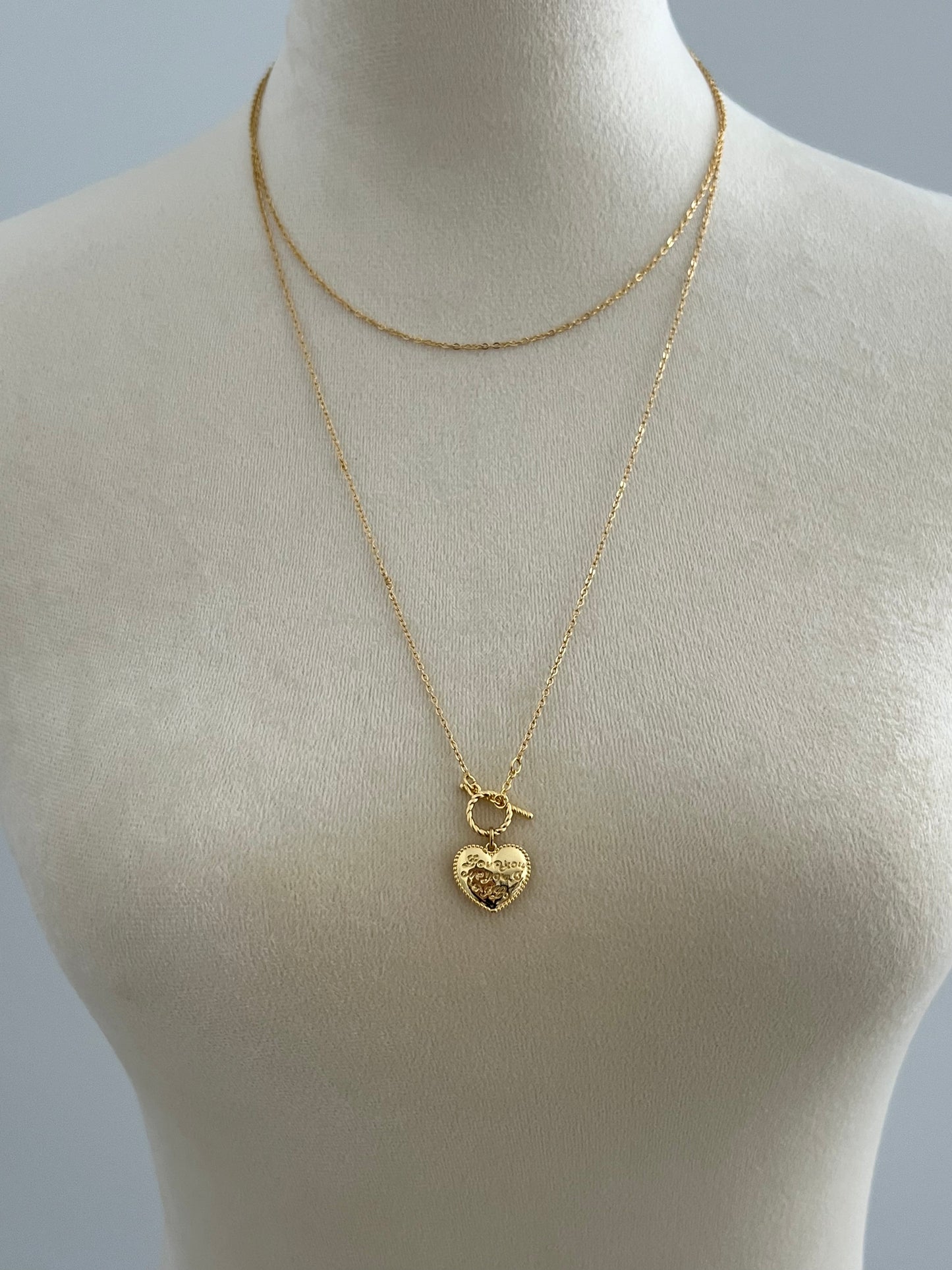 Gilded heart layered necklace on a mannequin