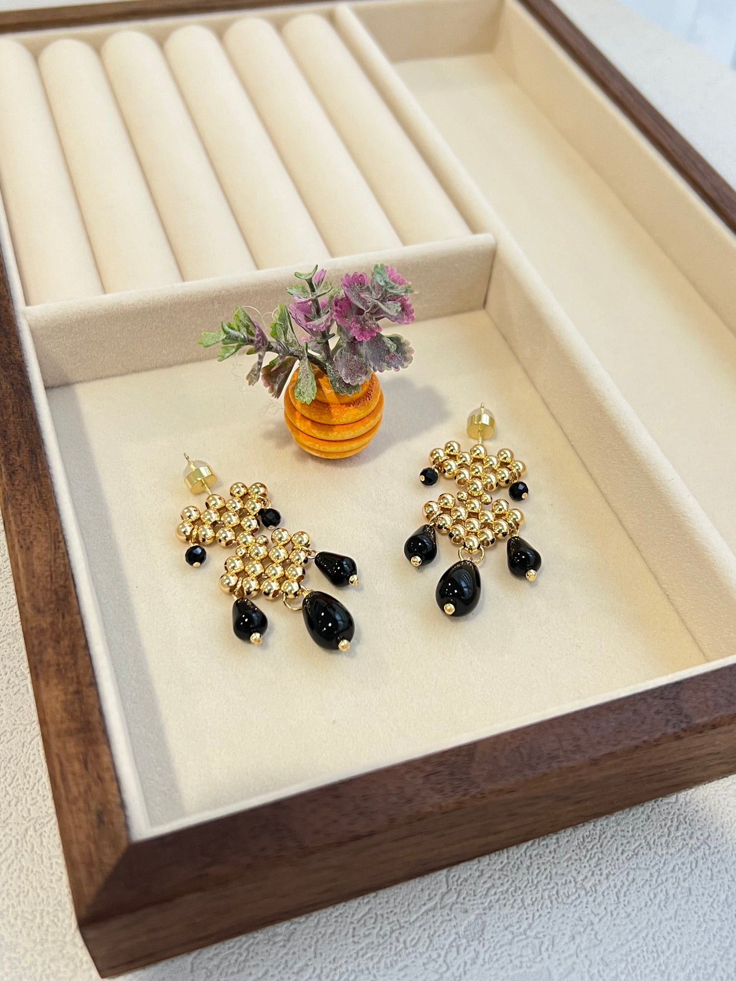 Double hearts earrings with agate next to a decorative plant