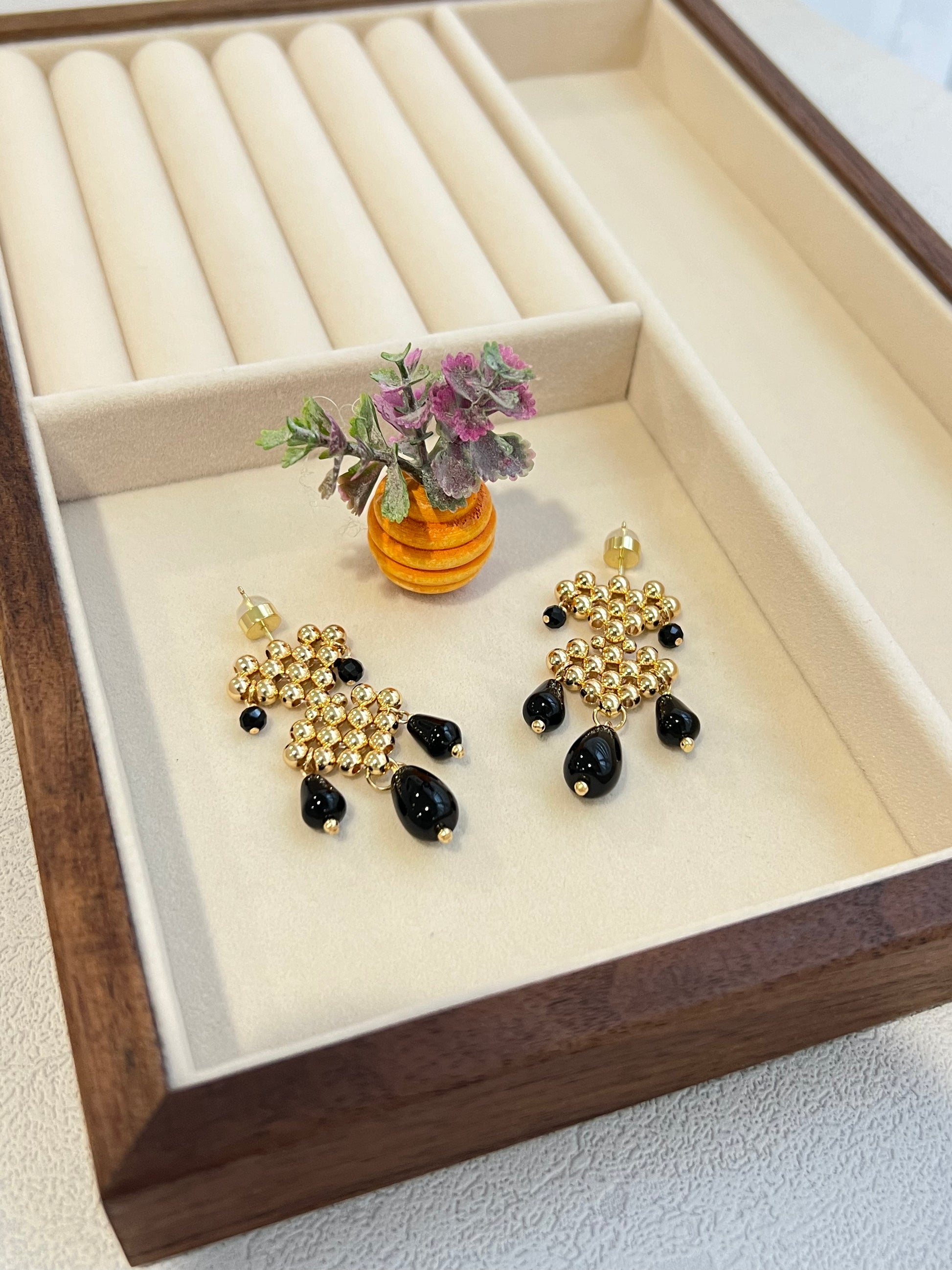 Double hearts earrings with agate next to a decorative plant