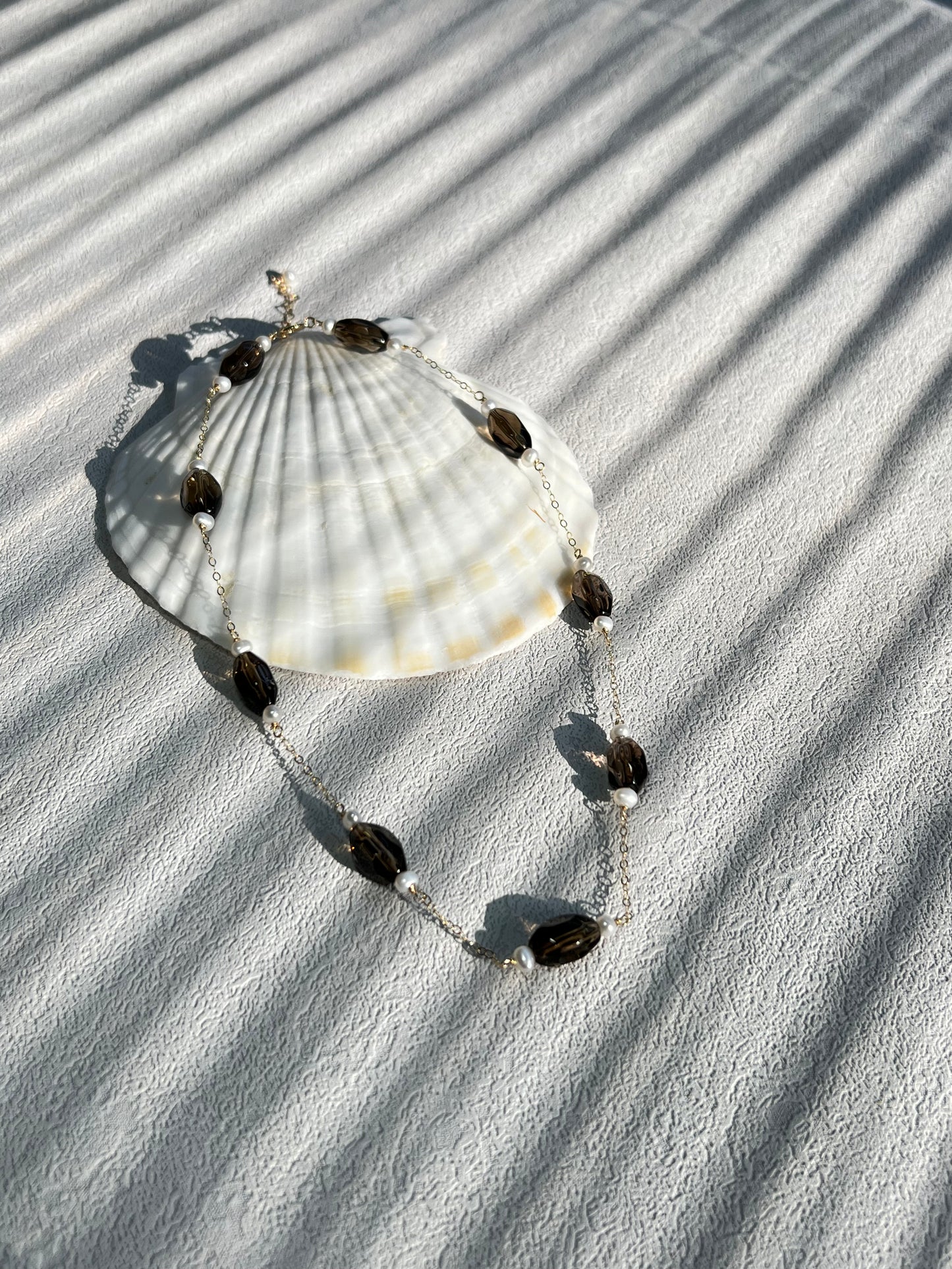 Smoky quartz & pearl choker necklace on a big shell