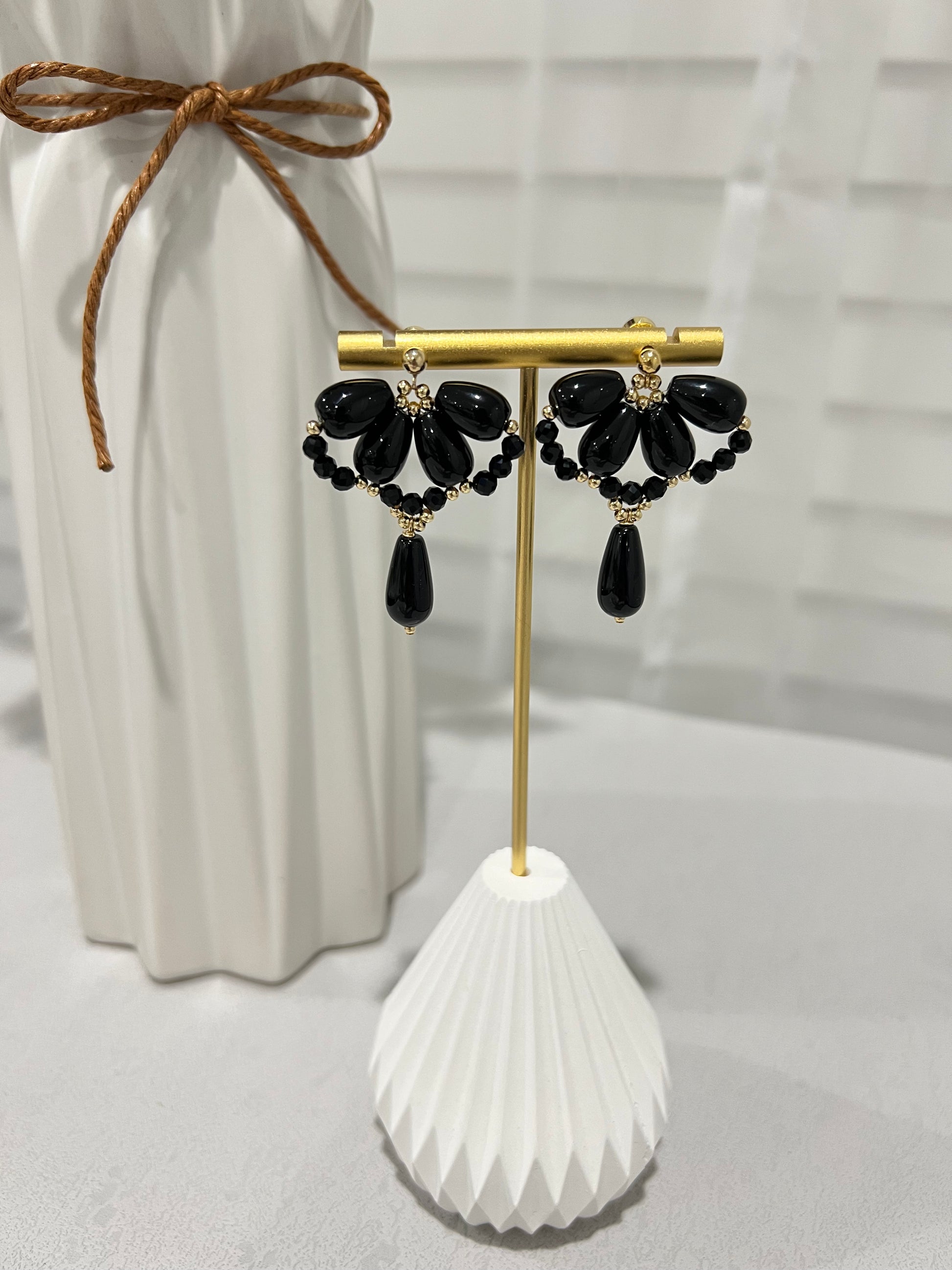 Black agate waterdrop earrings next to a vase