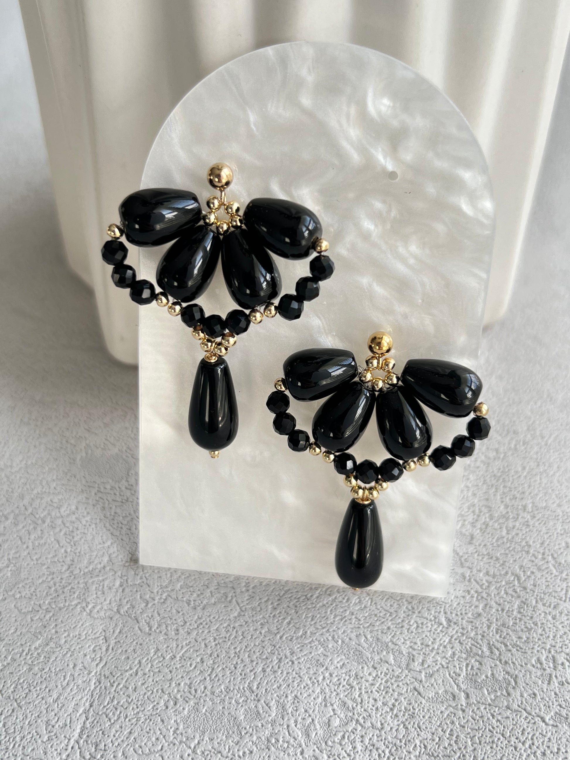 Black agate waterdrop earrings on a white board