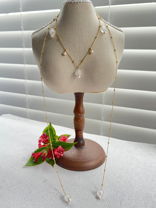 lily of the valley layered necklace next to a window