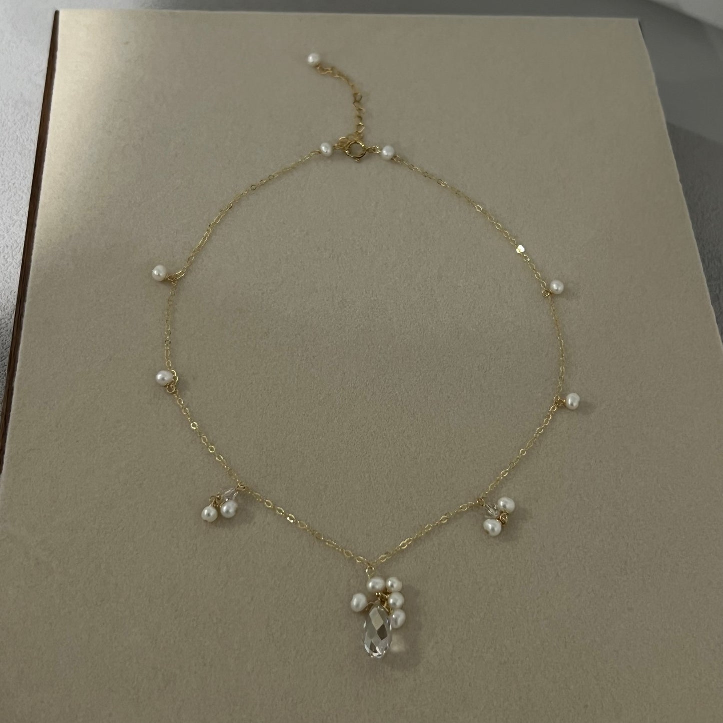 Swarovski crystal & pearls necklace on a beige board