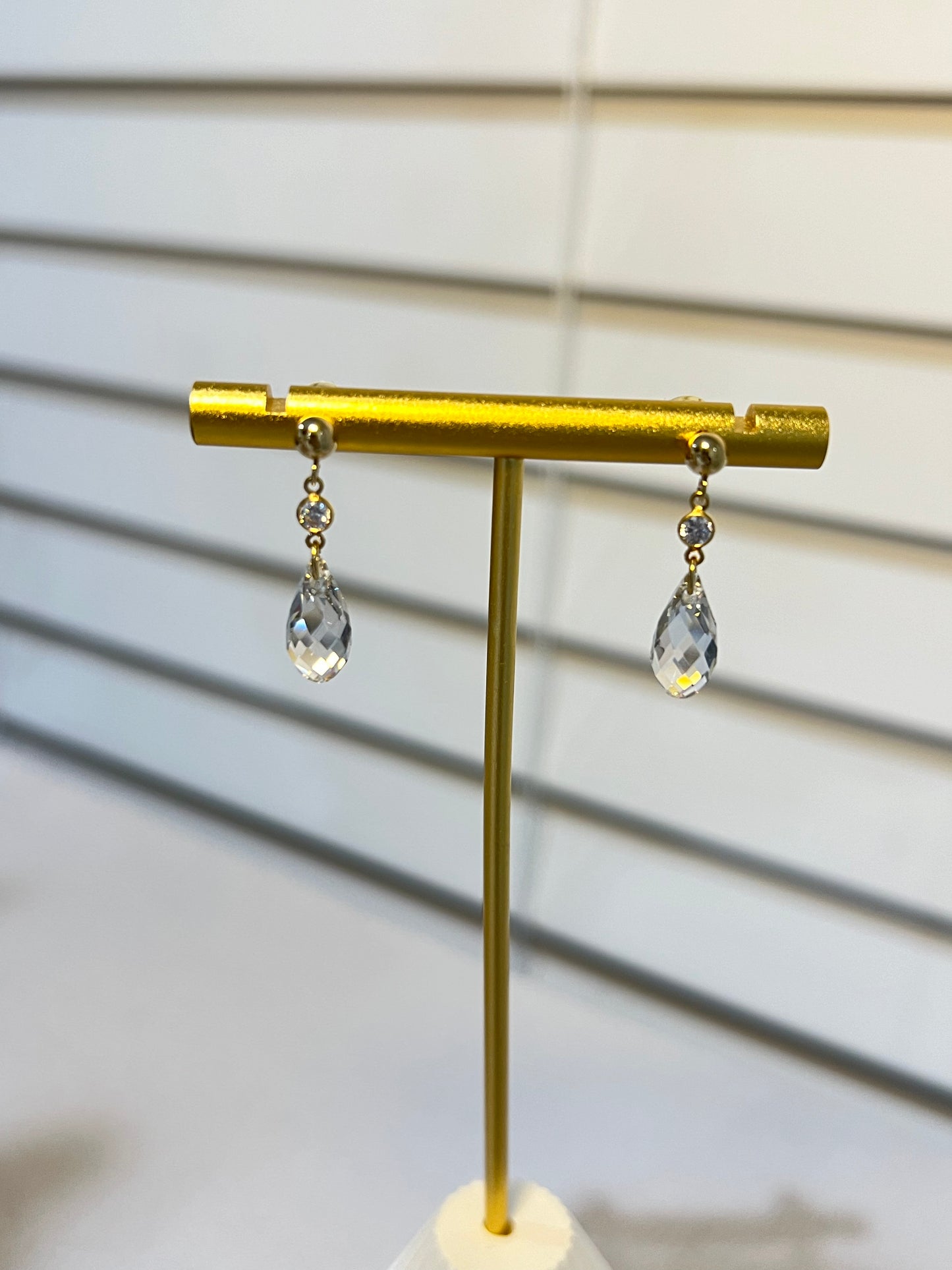 Short Swarovski crystal earrings next a window