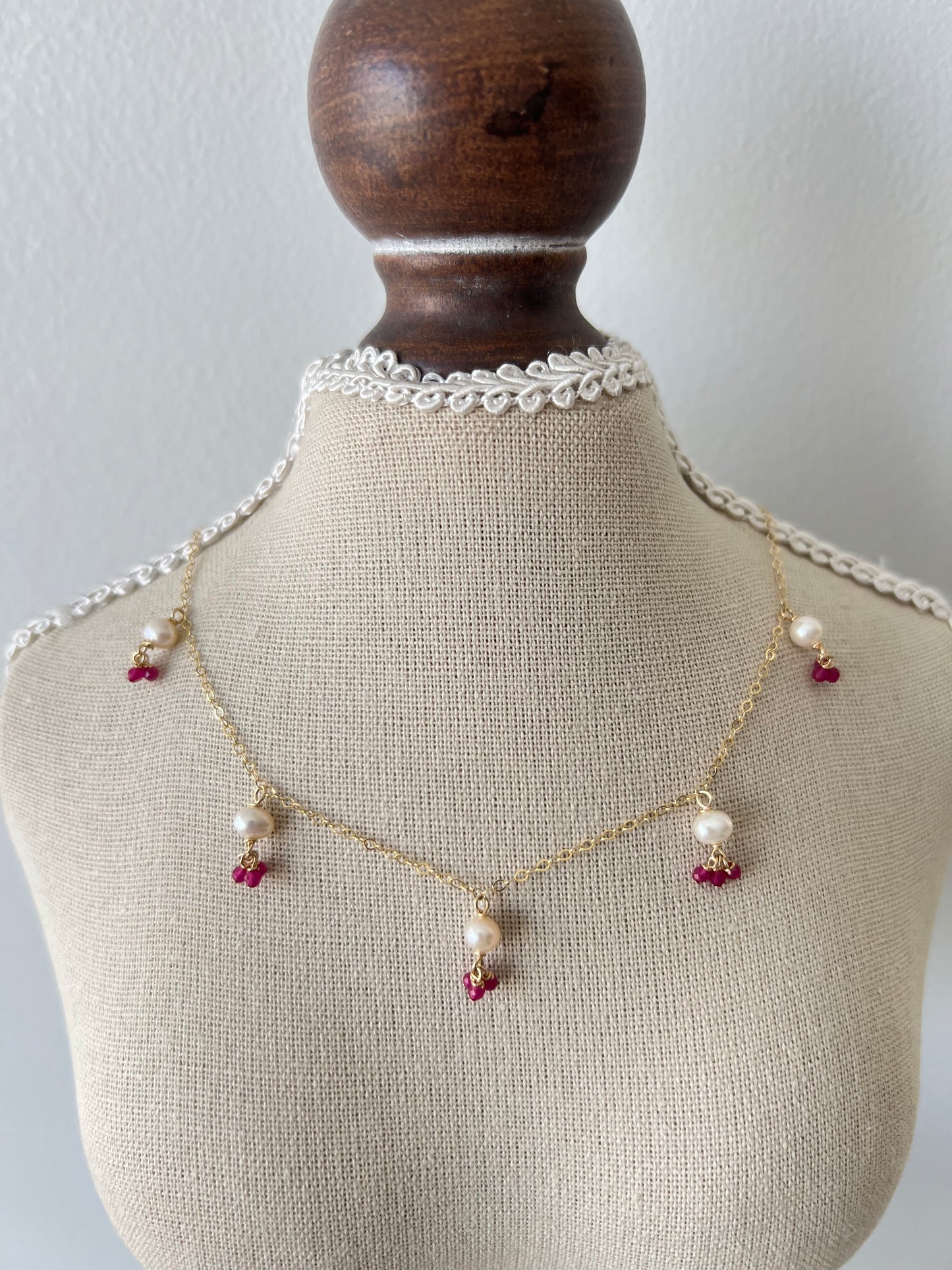 Pink gemstones & pearls necklace on a small mannequin