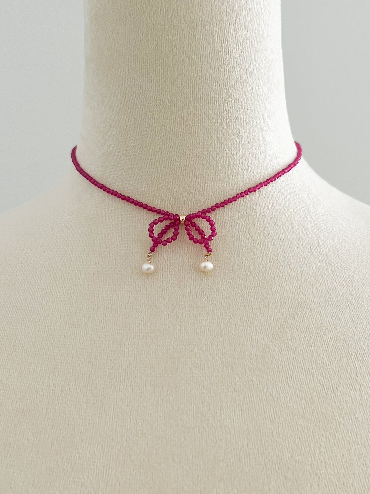 Pink gemstones choker necklace with a knot on a mannequin