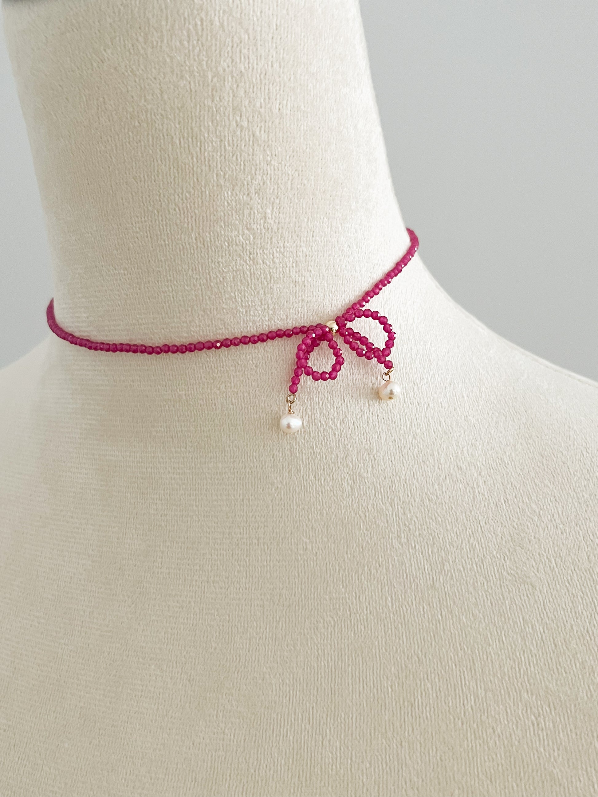 Pink gemstones choker necklace with a knot on a mannequin